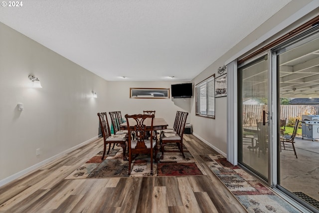 dining space with wood-type flooring and a healthy amount of sunlight