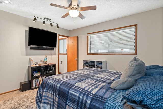 carpeted bedroom featuring a textured ceiling and ceiling fan