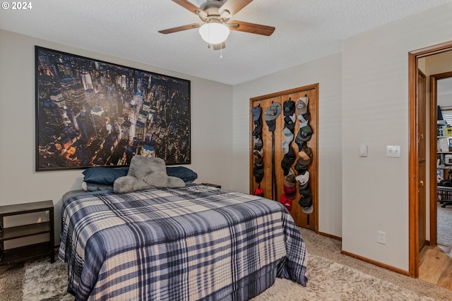 carpeted bedroom featuring a closet, ceiling fan, and a textured ceiling