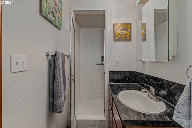 bathroom with vanity and a tile shower