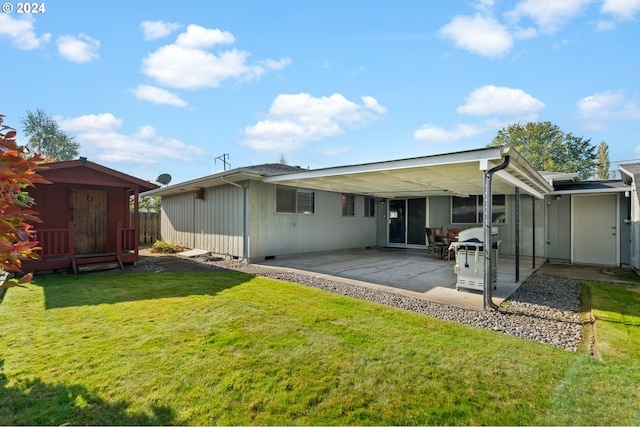 rear view of house featuring a patio, a storage shed, and a yard