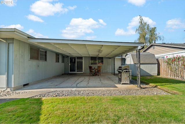 back of property with a yard, a patio, and a shed