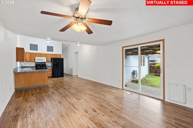 interior space featuring sink, black appliances, and light hardwood / wood-style flooring