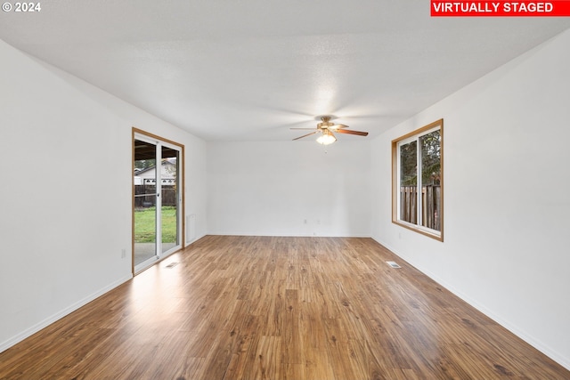 spare room with ceiling fan, wood-type flooring, a textured ceiling, and plenty of natural light