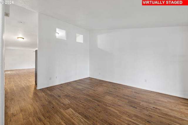 unfurnished room featuring dark wood-type flooring