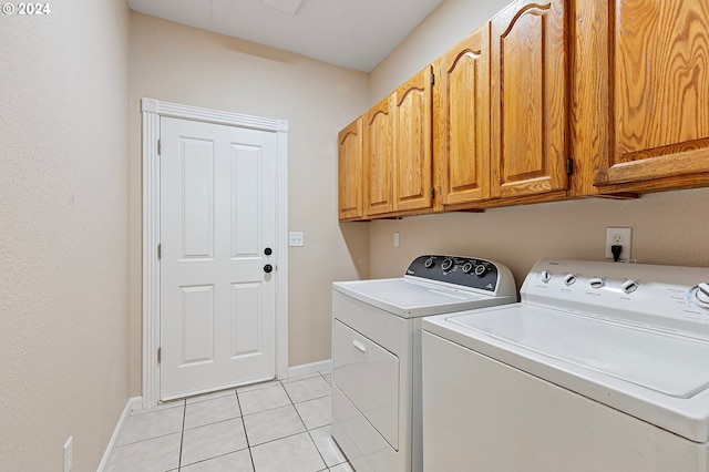 laundry area featuring washer and dryer, cabinets, and light tile patterned floors