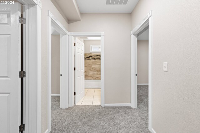 hall with light colored carpet