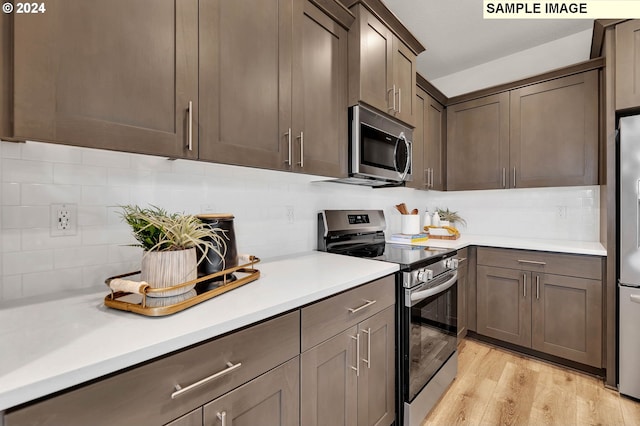 kitchen with light hardwood / wood-style floors, dark brown cabinets, decorative backsplash, and stainless steel appliances