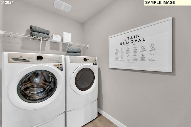 clothes washing area featuring light wood-type flooring and washer and dryer