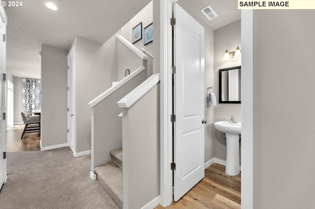 stairs with wood-type flooring and sink