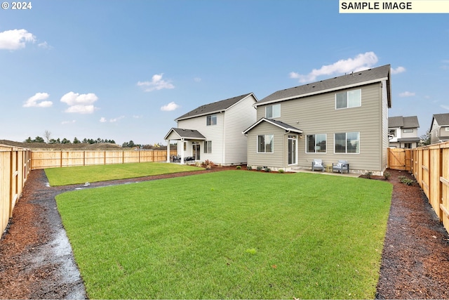 rear view of house featuring a lawn