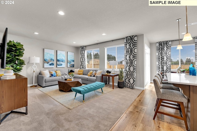 living room with light wood-type flooring and a textured ceiling