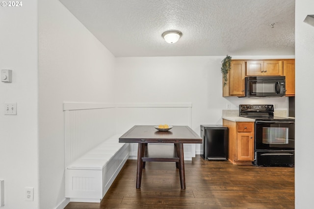 kitchen featuring black appliances, dark hardwood / wood-style floors, and a textured ceiling