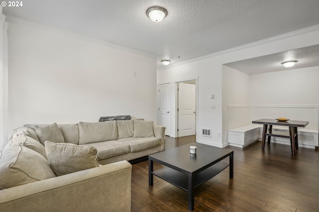 living room featuring dark hardwood / wood-style floors, crown molding, and a textured ceiling