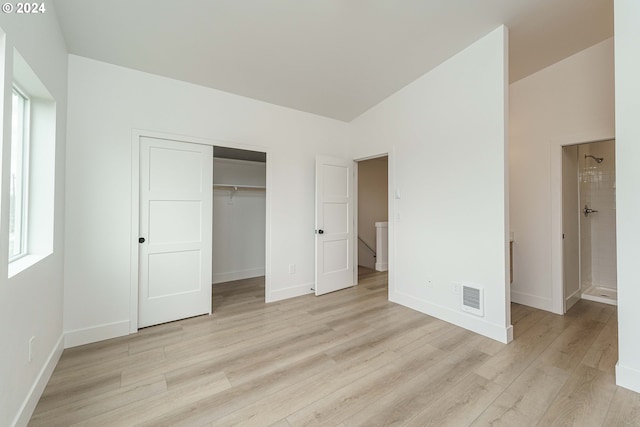 unfurnished bedroom with light hardwood / wood-style flooring and a closet