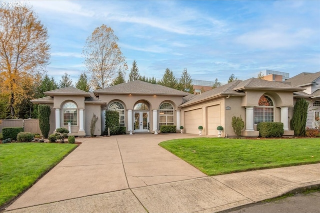 view of front of house featuring a front lawn, a garage, and french doors