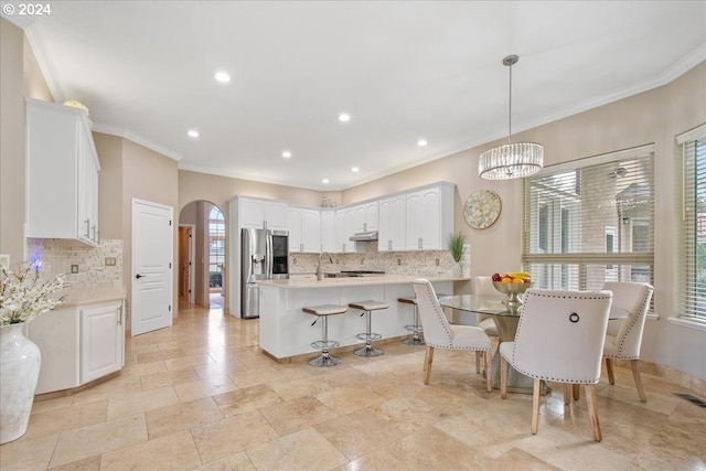 dining room featuring ornamental molding, a healthy amount of sunlight, and a notable chandelier