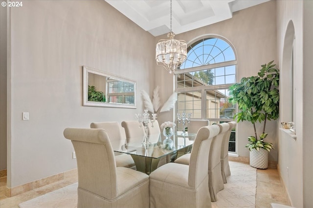 dining area featuring a towering ceiling and an inviting chandelier