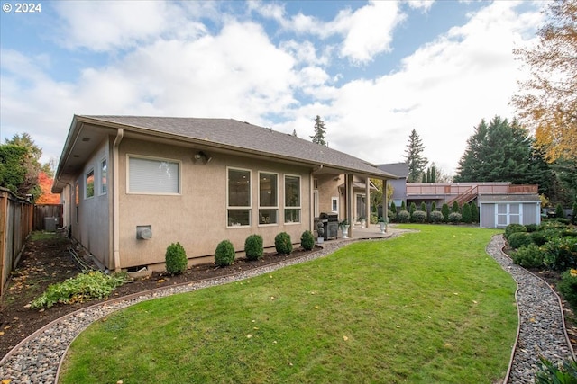 back of property with a lawn, a shed, a patio, and central AC