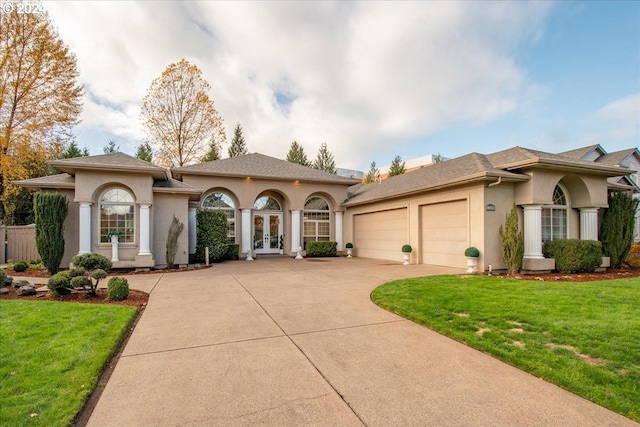 mediterranean / spanish house with french doors, a front lawn, and a garage