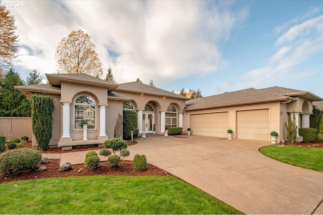 mediterranean / spanish house featuring a front yard and a garage