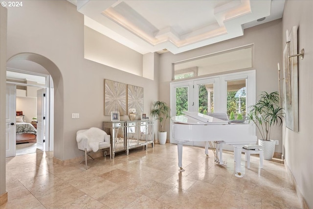 miscellaneous room featuring a tray ceiling and a high ceiling