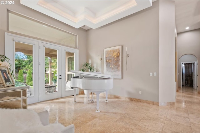 misc room with a tray ceiling, french doors, a towering ceiling, and ornamental molding