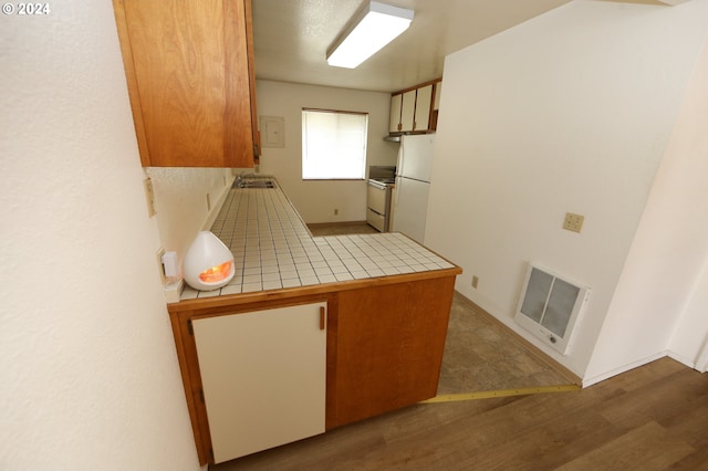 542 Pacific Ave, Brookings, OR 97415 - kitchen featuring tile counters, white appliances, a sink, wood finished floors, and a peninsula