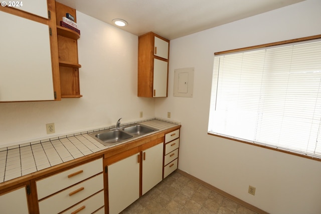 542 Pacific Ave, Brookings, OR 97415 - kitchen with a sink, tile counters, open shelves, electric panel, and baseboards