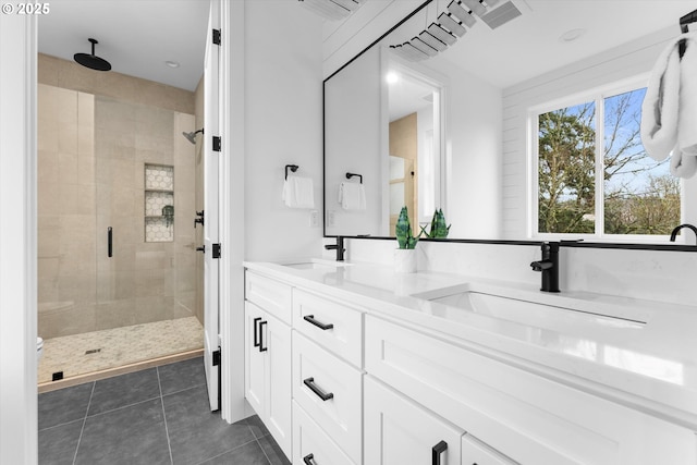 bathroom featuring tile patterned floors, a shower with door, and vanity