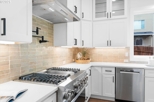 kitchen with backsplash, stainless steel appliances, extractor fan, and white cabinets