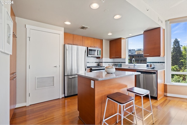 kitchen featuring a center island, a breakfast bar, a healthy amount of sunlight, and appliances with stainless steel finishes