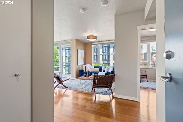 hallway featuring light hardwood / wood-style flooring and a textured ceiling