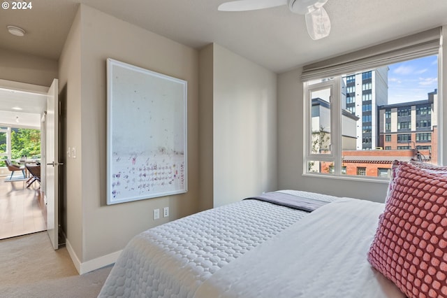 bedroom with ceiling fan and light carpet