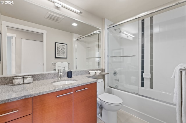 full bathroom featuring tile patterned floors, vanity, enclosed tub / shower combo, and toilet