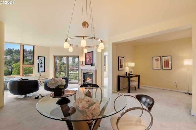 carpeted dining space featuring a premium fireplace and a chandelier