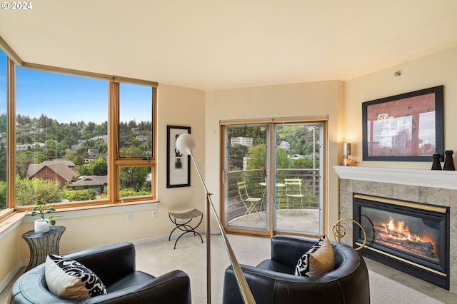 living room featuring a tile fireplace and light carpet