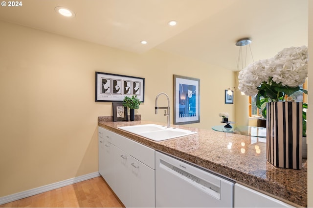 kitchen with white dishwasher, sink, white cabinets, and light hardwood / wood-style flooring