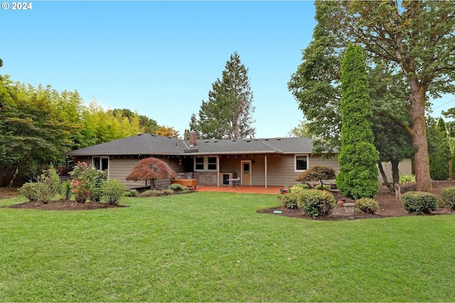 back of property with a patio area and a yard