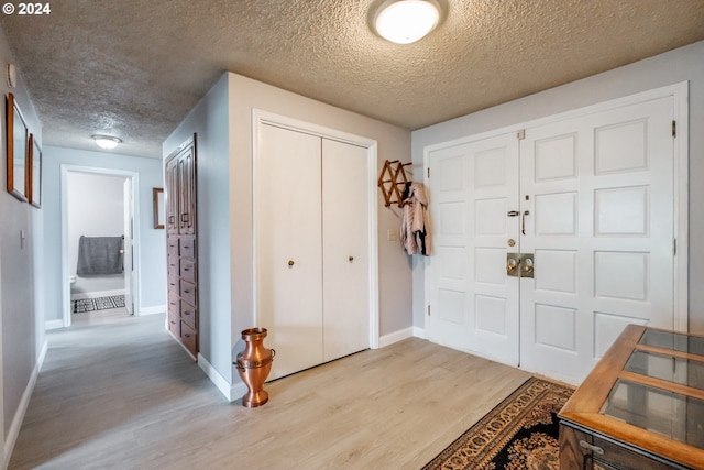 foyer with a textured ceiling and light wood-type flooring