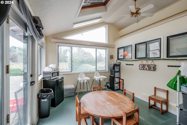 dining room with a healthy amount of sunlight, carpet, and lofted ceiling