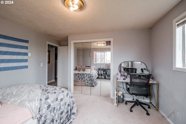 carpeted bedroom featuring a closet and a textured ceiling