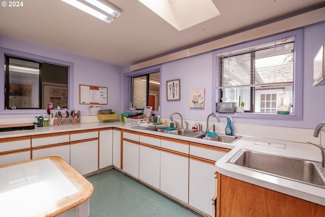 kitchen featuring white cabinetry, sink, and kitchen peninsula