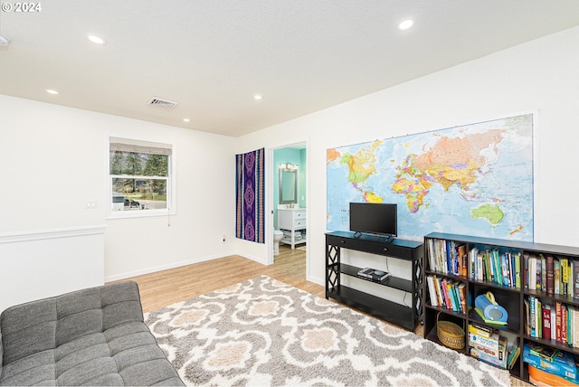 living area featuring light wood-style floors, baseboards, visible vents, and recessed lighting