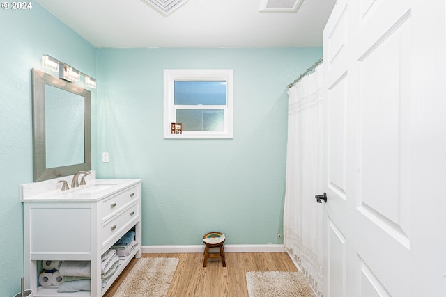 bathroom featuring curtained shower, wood finished floors, visible vents, vanity, and baseboards