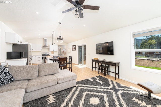 living area featuring lofted ceiling, a ceiling fan, light wood-style flooring, and baseboards