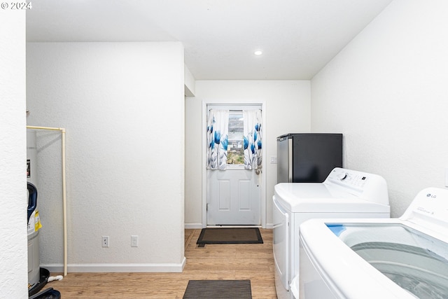 washroom featuring laundry area, baseboards, light wood-style flooring, washing machine and dryer, and recessed lighting