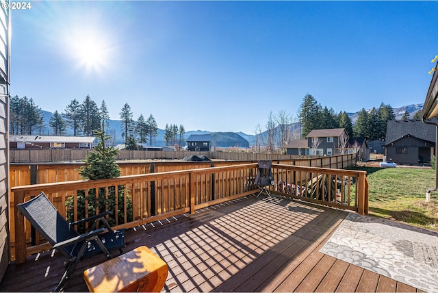 wooden deck featuring a residential view, a fenced backyard, and a mountain view