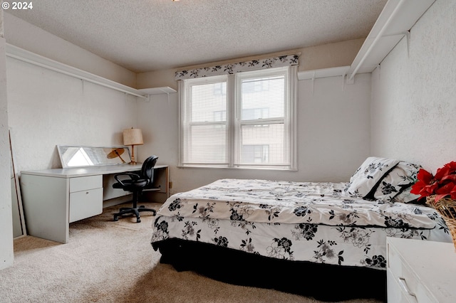 bedroom with light colored carpet and a textured ceiling