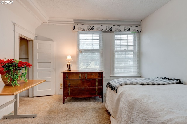 carpeted bedroom with a textured ceiling and crown molding